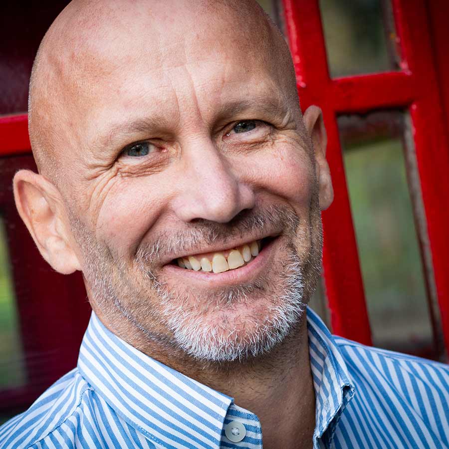 Male client head shot in front of red telephone box