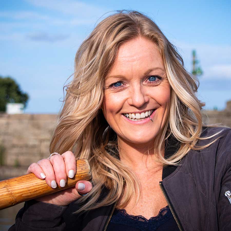 Female with blonde hair rowing a boat