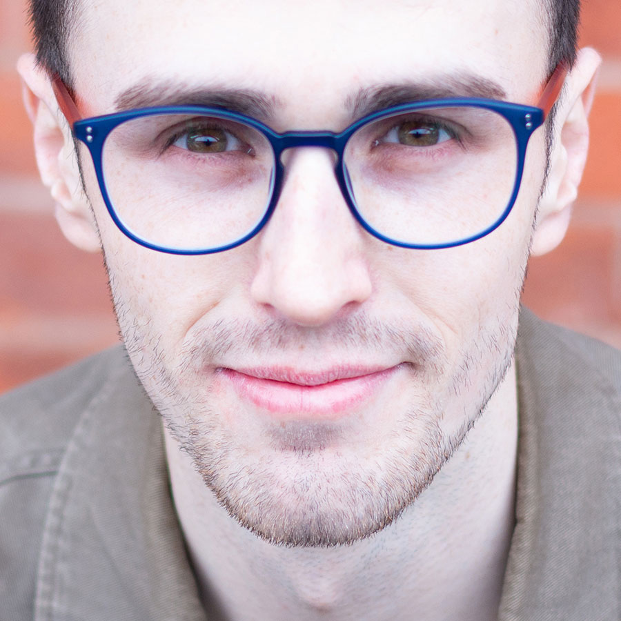 Male looking at the camera in blue-rimmed glasses