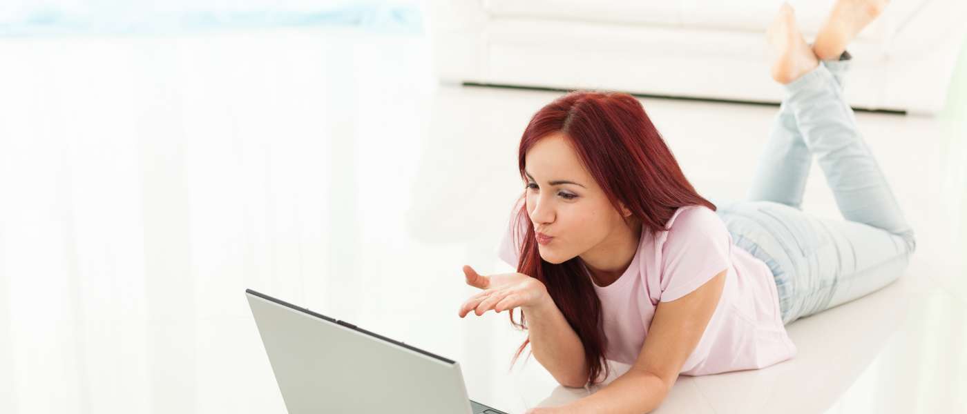 Woman on laptop reading about how to you stand out when online dating