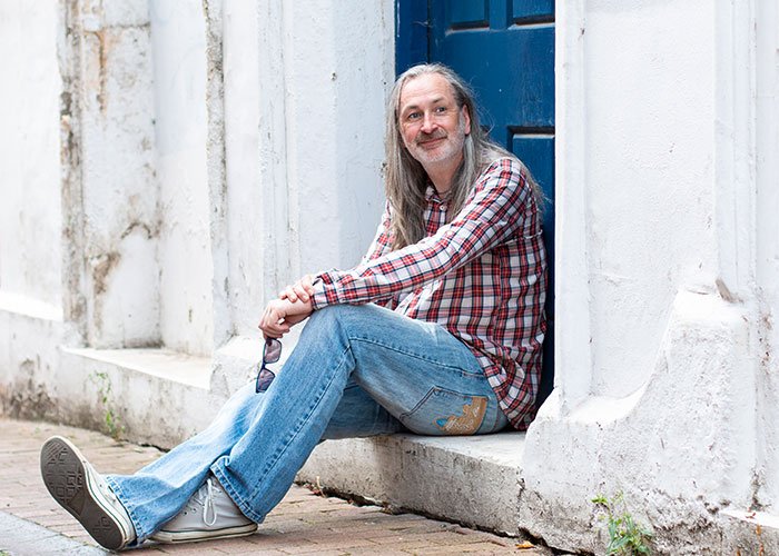 Dating photo of man in checked shirt sitting on steps